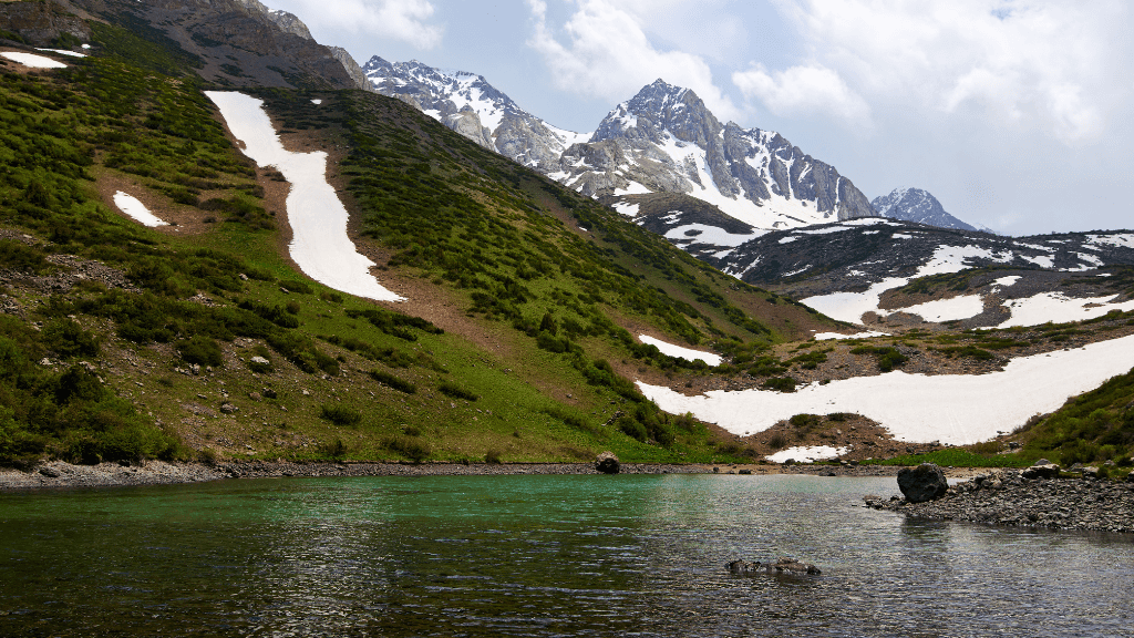 Mountain lake with snow patches in the Fann Mountains, perfect for hiking on the Silk Road Cities Tour - Central Asia Adventure.