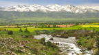 Mountain valley with river and green fields in Kyrgyzstan, a scenic view on the Silk Road Cities Tour - Central Asia Adventure.