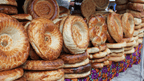 Stacks of traditional Uzbek bread at a local market, a culinary highlight of the Silk Road Cities Tour - Central Asia Adventure.