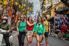 Group of friends walking through a decorated street in Vietnam. Cultural immersion on Vietnam Hiking and Cycling Tour.