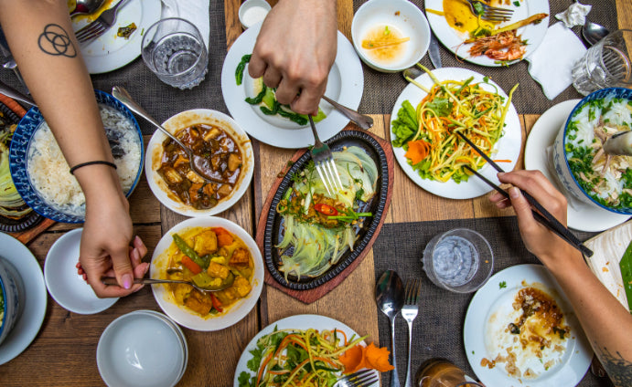 Top view of Vietnamese dishes being shared at a group meal. Culinary experience on Vietnam Hiking and Cycling Tour.