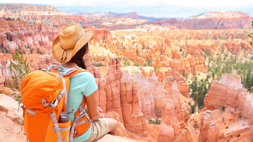 Female hiker overlooking Bryce Canyon's hoodoos on Western USA Parks Tour - 9, 16, 18 Days | Parks & Peaks. Ideal for active explorers and families.