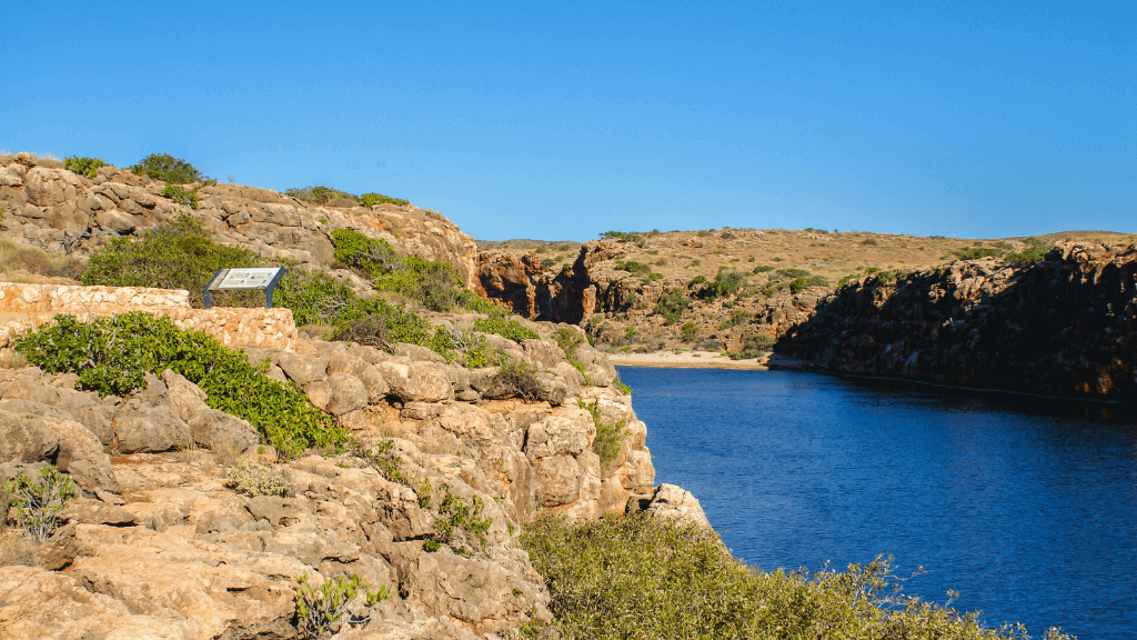 Scenic view of rocky cliffs and turquoise waters at Cape Range National Park, Western Australia.