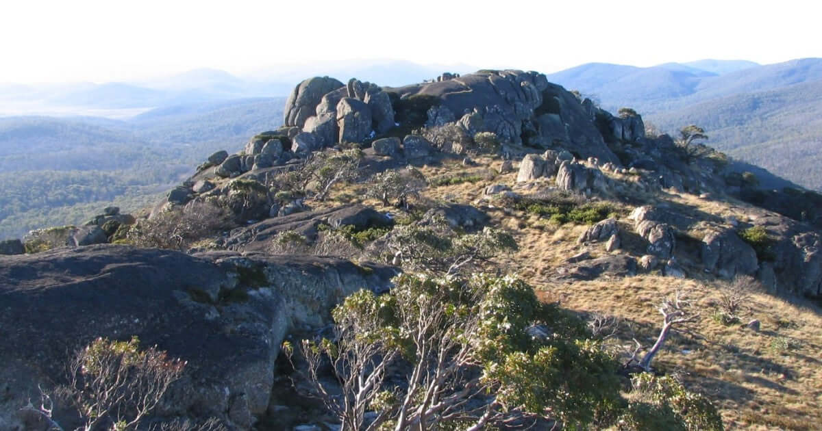 Rocky summit of Mt Bimberi with panoramic views of Namadgi National Park, ideal for hiking and adventure tours in Australia.