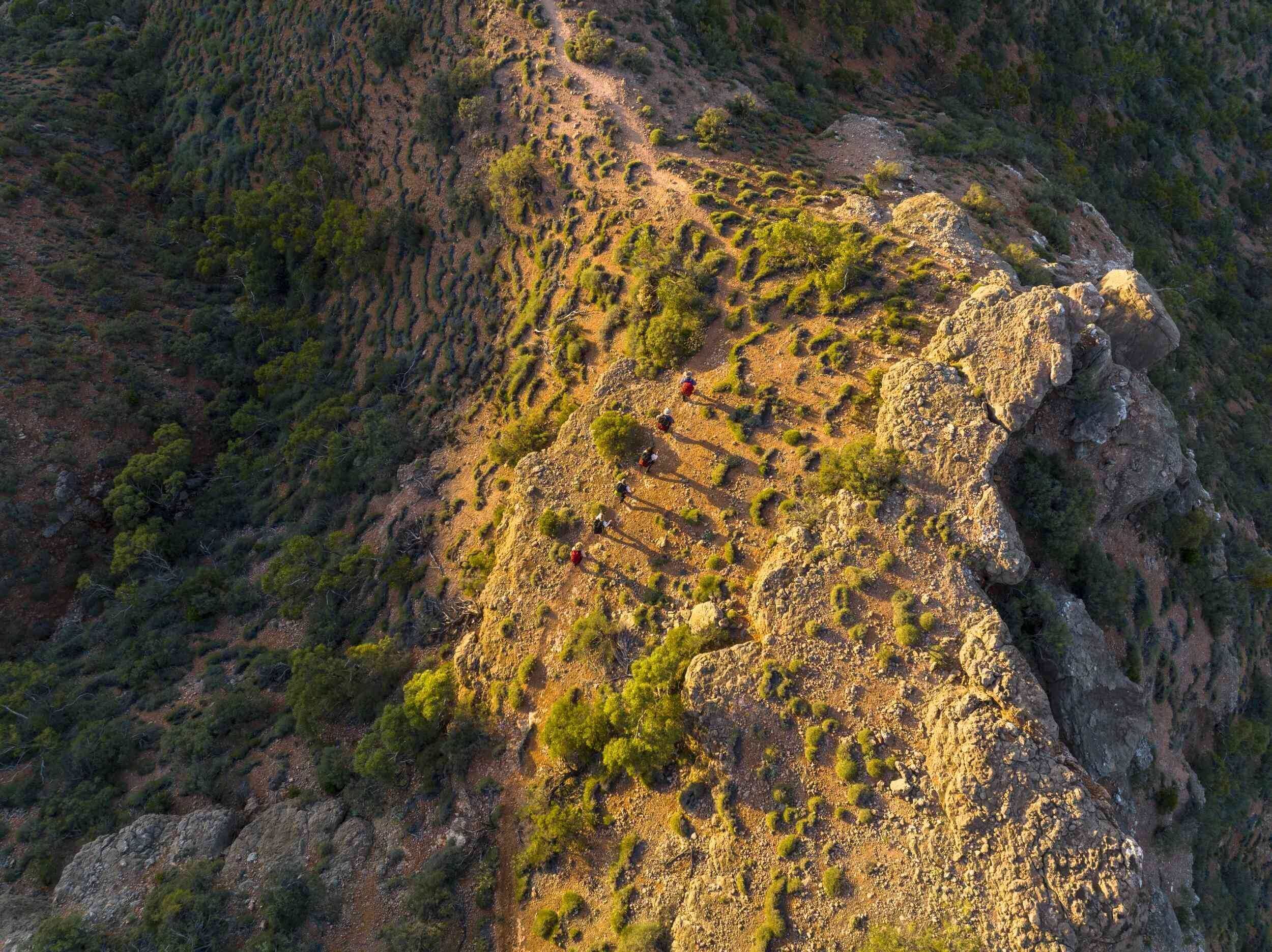 Aerial view of hikers on a rugged trail in the Cape Range, showcasing a stunning outdoor adventure.