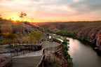 Couple enjoying sunset views on a scenic river walk in Australia's Top End wilderness.