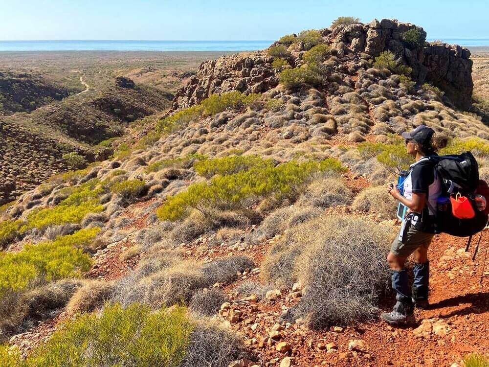Hiker exploring rugged landscape on Cape Range, embracing adventure and the outdoors during a 3-day trek.